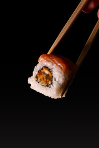 Fotografía gastronómica de sushi con palillos en Valencia